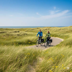 2 mensen fietsen met een e-bike in de duinen