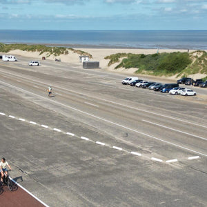 2 meisjes fietsen langs het strand